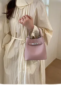 Macro view of pink lychee leather texture and metallic buckle detail on bucket bag