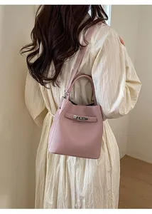 Detail of pink lychee leather bucket bag with silver metal buckle and adjustable strap