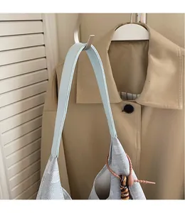 Detail of the light blue leather long shoulder strap on a grey textured tote bag