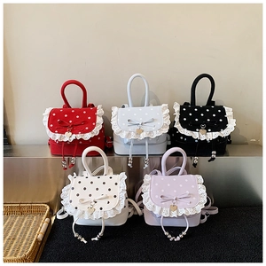 Détail de mini sacs à dos à pois en couleurs variées avec dentelle et nuds décoratifs
