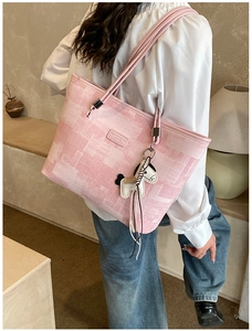 Detail of pink plaid tote bag featuring a cute horse charm and a minimalist logo patch