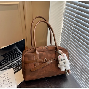 Brown textured fabric tote bag with leather trim and white puppy charm in office setting