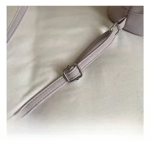Détail de la boucle réglable argentée sur une bandoulière de sac en cuir violet clair