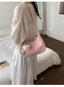 Sac à bandoulière rose texture litchi avec breloque poupée mignonne en détail