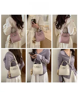 Detail of lychee pattern leather bucket bag with metal twist lock and cute bear charm