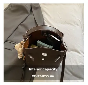 Interior capacity of vintage brown leather bucket bag showing smartphone and makeup items