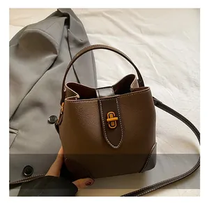 Close-up of pebble leather bucket bag with gold twist lock and handle details