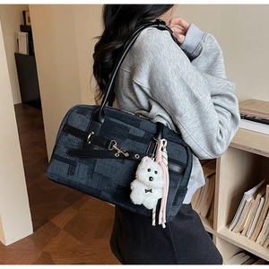 Detail of navy textured PU tote bag with leather handle and cute plush dog charm