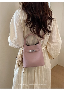 Detailed back view of a pink lychee grain bucket bag with teddy bear charm and metal buckle