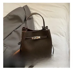 Detail of dark brown lychee grain bucket bag with silver metal twist lock and top handle
