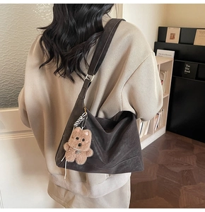 Retro dark brown frosted leather hobo bag with cute plush bear charm on model
