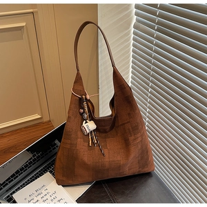 Détail d'un sac cabas en daim marron avec charme café et large bandoulière chic