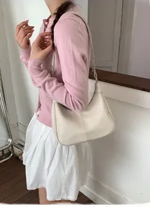 Vue détaillée du sac hobo de couleur crème montrant la texture du cuir et la boucle