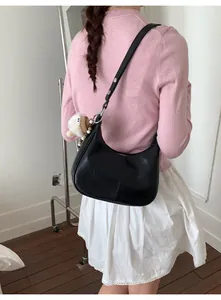 Détail du sac hobo en similicuir noir avec un joli pendentif mouton en peluche