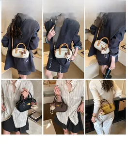 Détail du sac à bandoulière vintage Boston avec breloque ours et plaque logo dorée chic