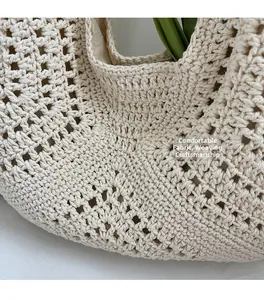 Gros plan d'un cabas tissé montrant la texture au crochet et la doublure en tissu beige