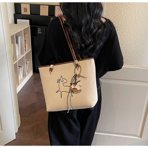 Detail of cream tote bag featuring a black pony sketch and brown leather handle