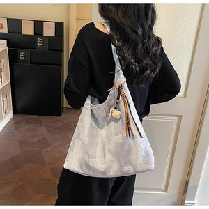 Détail du cabas bleu clair texturé avec charm tasse à café et pompon tressé élégant