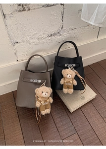 Macro shot of litchi grain bucket bags with silver locks and teddy bear charms