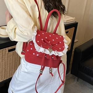 Zaino rosso a pois con pizzo bianco e ciondolo a fiocco indossato dalla modella