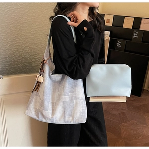 Detailed shot of large canvas tote bag with letter charm and blue leather pouch
