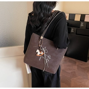 Close-up of a dark brown vintage tote bag with horse embroidery and hanging charm