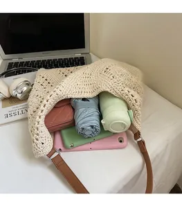 Intérieur spacieux du sac fourre-tout en tricot beige contenant parapluie et tablettes