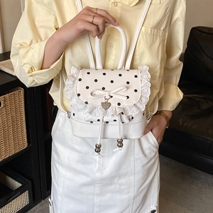 Dettaglio mini zaino a pois con bordo in pizzo bianco e fiocco decorativo