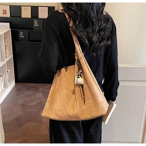 Detail of khaki tote bag featuring coffee cup charm and soft faux suede texture