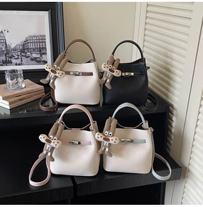 Detailed row of four stylish bucket bags with leather straps and plush rabbit charms