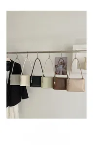Minimalist soft leather bucket bags shown in six classic colors hanging on a metal rack