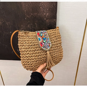 Detail of bohemian straw bag featuring colorful beadwork and stylish fringe accents