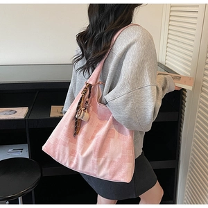 Détail du sac cabas géométrique rose clair avec foulard rayé et pendentif café