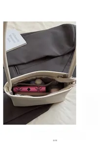 Internal view of the white shoulder bag showing main compartment with phone and wallet