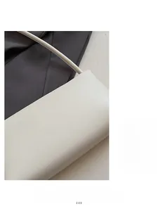 Detailed close-up of the smooth white leather texture and stitching of the baguette handbag