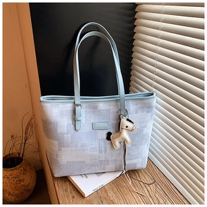 Detail of blue plaid tote bag with FASHION & BAGS leather label and horse charm