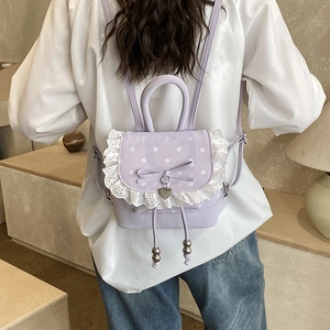 Dettaglio vista posteriore di un mini zaino viola chiaro con pois bianchi e pizzo