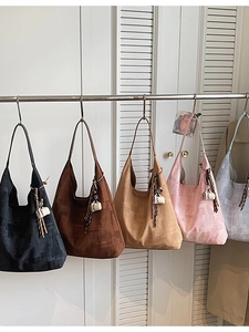 Grands sacs cabas minimalistes en plusieurs couleurs suspendus à un rack en métal