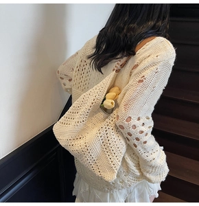 Gros plan détaillé du sac cabas en tricot crème avec tissage ajouré et finition cuir