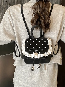 Mini zaino nero a pois bianchi con pizzo e fiocco, vista posteriore indossata