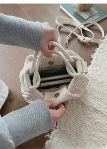 Detail of spacious interior with magnetic closure on cream woven shoulder bag