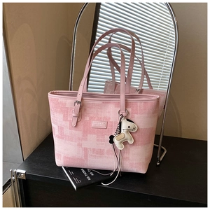 Close-up of pink geometric pattern tote bag with leather trim and horse charm