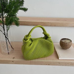 Detail of green ruched cloud bucket bag with textured leather and knot handle