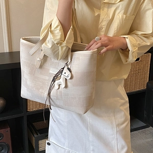 Detail view of large apricot tote bag featuring textured finish and pony charm