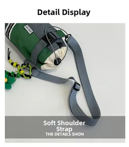 Detail of gray and green ripstop bag showing adjustable strap and drawstring closure