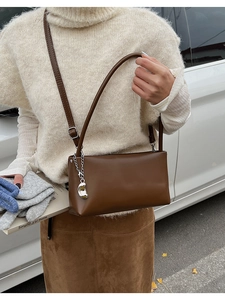 Brown rectangular faux leather shoulder bag with silver chain and metal bean charm