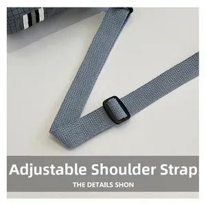 Detail of adjustable woven canvas strap and buckle on a grey plaid outdoor water bottle bag