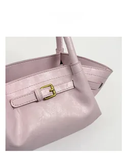 Macro shot of pink bucket bag with fine leather texture and golden metal buckle details