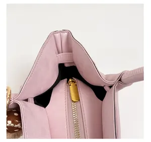 Detail of pink bucket bag with gold metal zipper and black lining interior texture
