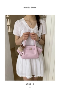 Detailed view of light pink bucket bag with plush bear charm and metallic buckle